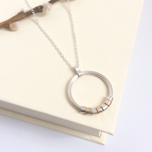 Circle necklace with silver and gold moving pieces